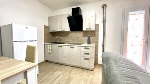 A compact kitchen with a sink, cabinets, and a refrigerator. - ALLOGGI DEL MIRTO - MILLY DEL MIRTO (Capoliveri)