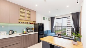 A modern kitchen with a dining area, a refrigerator, and a view of the city.