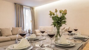 Una tavola imbandita con piatti, bicchieri e un vaso di fiori in una moderna camera d'albergo.