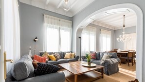 Ein geräumiges Wohnzimmer mit einer Sofagarnitur, einem Couchtisch und einem Essbereich mit einer Kronleuchter.