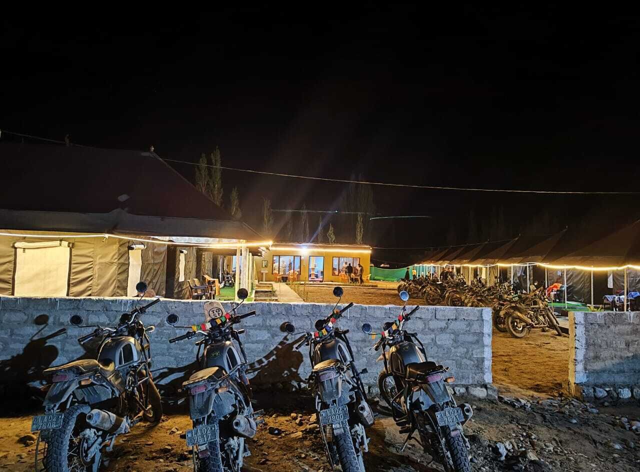 A group of motorcycles parked in front of a building at night.