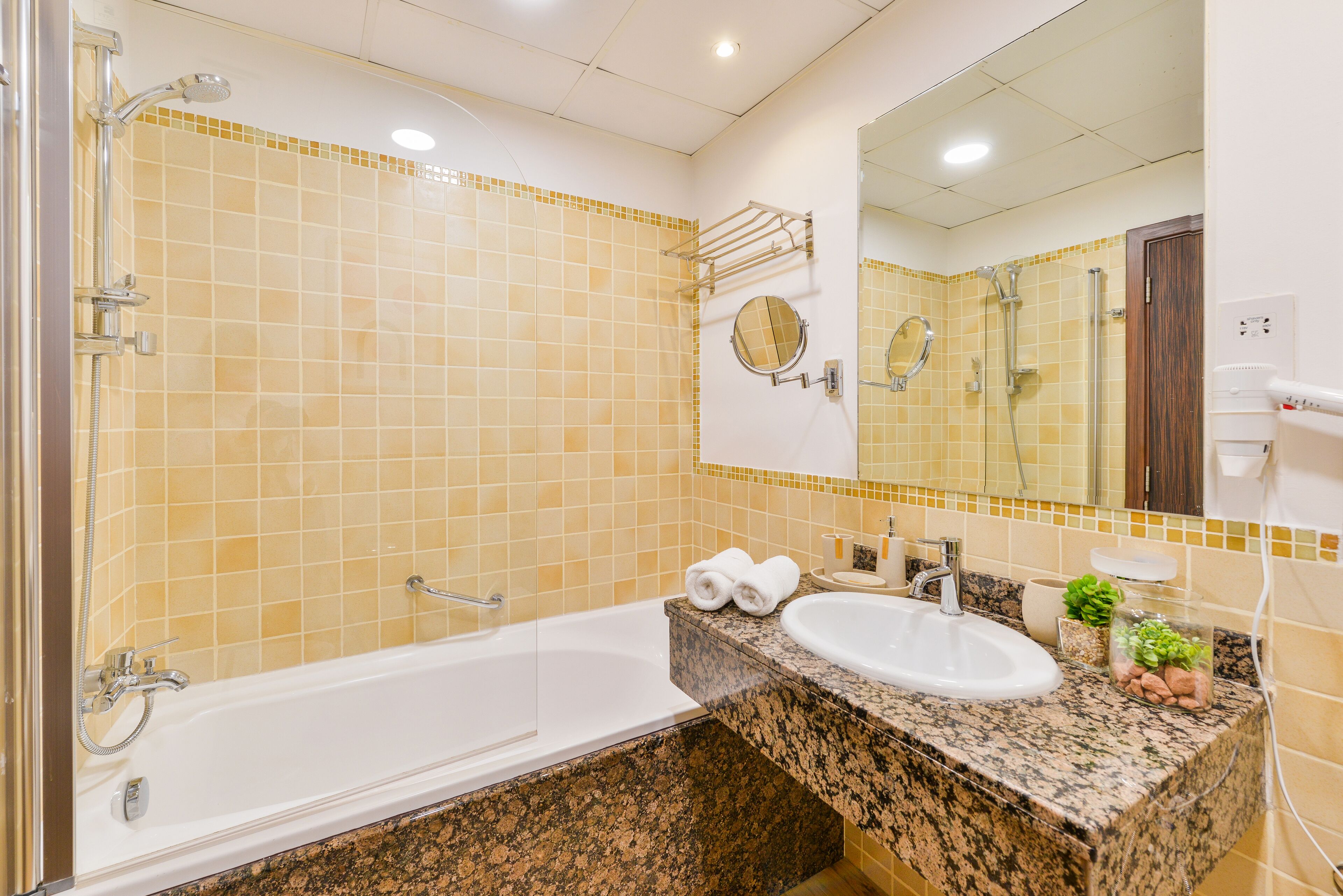 A bathroom with a bathtub, a sink, and a mirror.