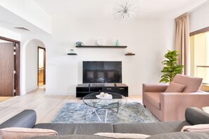Deluxe 2BR Apartment | Zona de estar | Smart TV de 55 pulgadas con canales por cable, una televisión