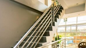 A modern staircase with metal railings and a handrail, leading to an upper floor. - FB Budgetel Suites (Cagayan de Oro)