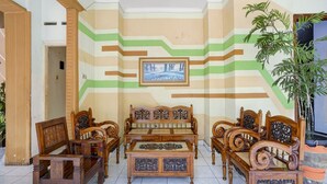 A room with a sofa set, a coffee table, and a potted plant. - OYO Life 3956 Hotel Palem 2 Syariah (Malang)