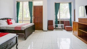 A hotel room with two beds, a wooden wardrobe, a small table, and a chair. - OYO Life 3956 Hotel Palem 2 Syariah (Malang)