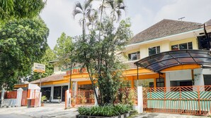 A hotel with a signboard, a covered entrance, and a gated driveway. - OYO Life 3956 Hotel Palem 2 Syariah (Malang)