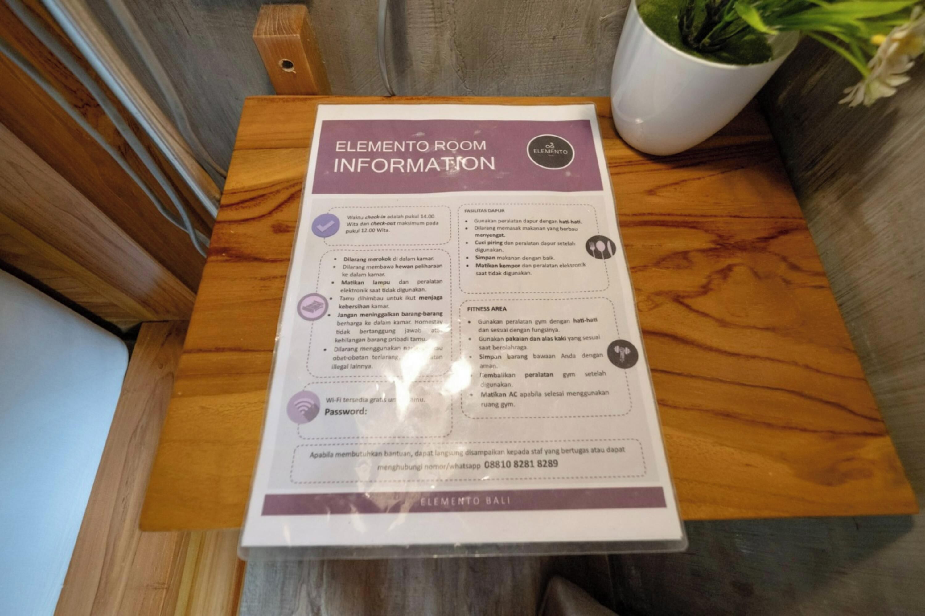 A sign with ELEMENTO ROOM INFORMATION on a wooden table.