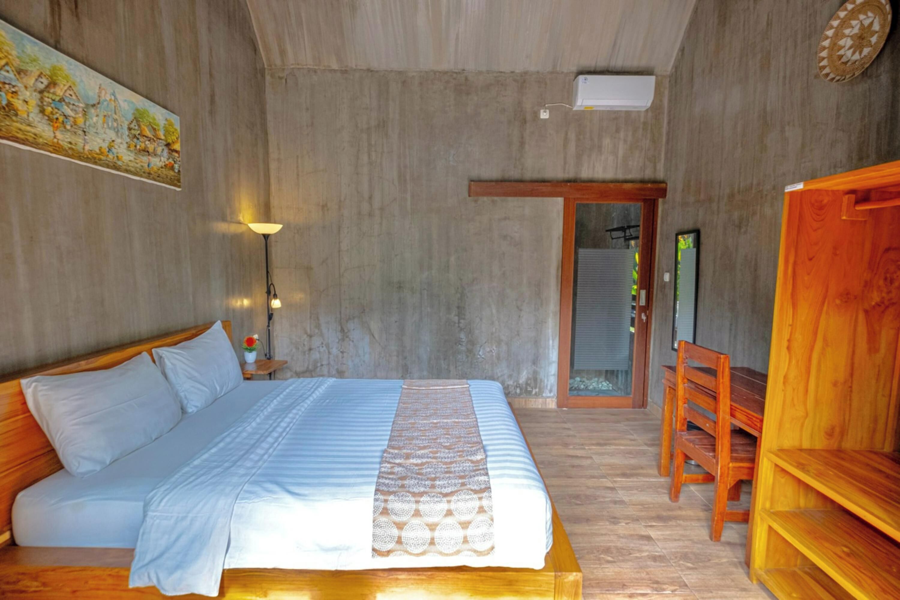 A bedroom with a bed, bedside table, lamp, and a wooden chair.