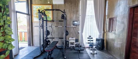 A gym with a squat rack, bench, and weight plates.