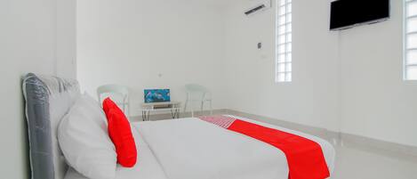 Une chambre d’hôtel avec un lit, un bureau, une chaise, une télévision et une fenêtre.