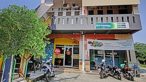 Een gebouw met een bord waarop 'Pegadaian' en 'OYO' staan, wat een hotel en restaurant aangeeft.