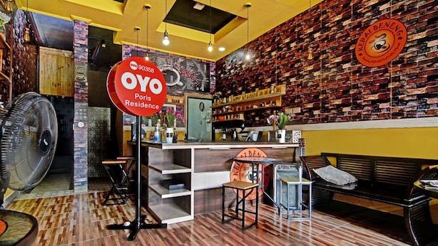 Een gezellig restaurantinterieur met een bakstenen muur, houten meubels en een ventilator.