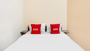 A bed with white bedding and two red pillows with the word "OYO" on them. - OYO 91361 Benlin D'kost Syariah (Surabaya)