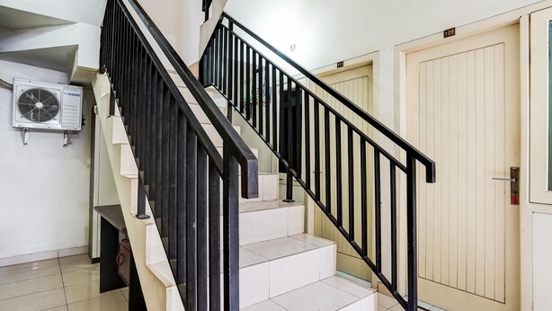 A staircase with black railings and beige steps, leading to a door marked with the number 109. - OYO 91361 Benlin D'kost Syariah (Surabaya)