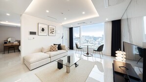 Una sala de estar moderna con sofá, mesa de centro y vista a la ciudad.
