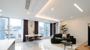 Una sala de estar moderna con un sofá, una mesa de centro y un comedor con una mesa y sillas.