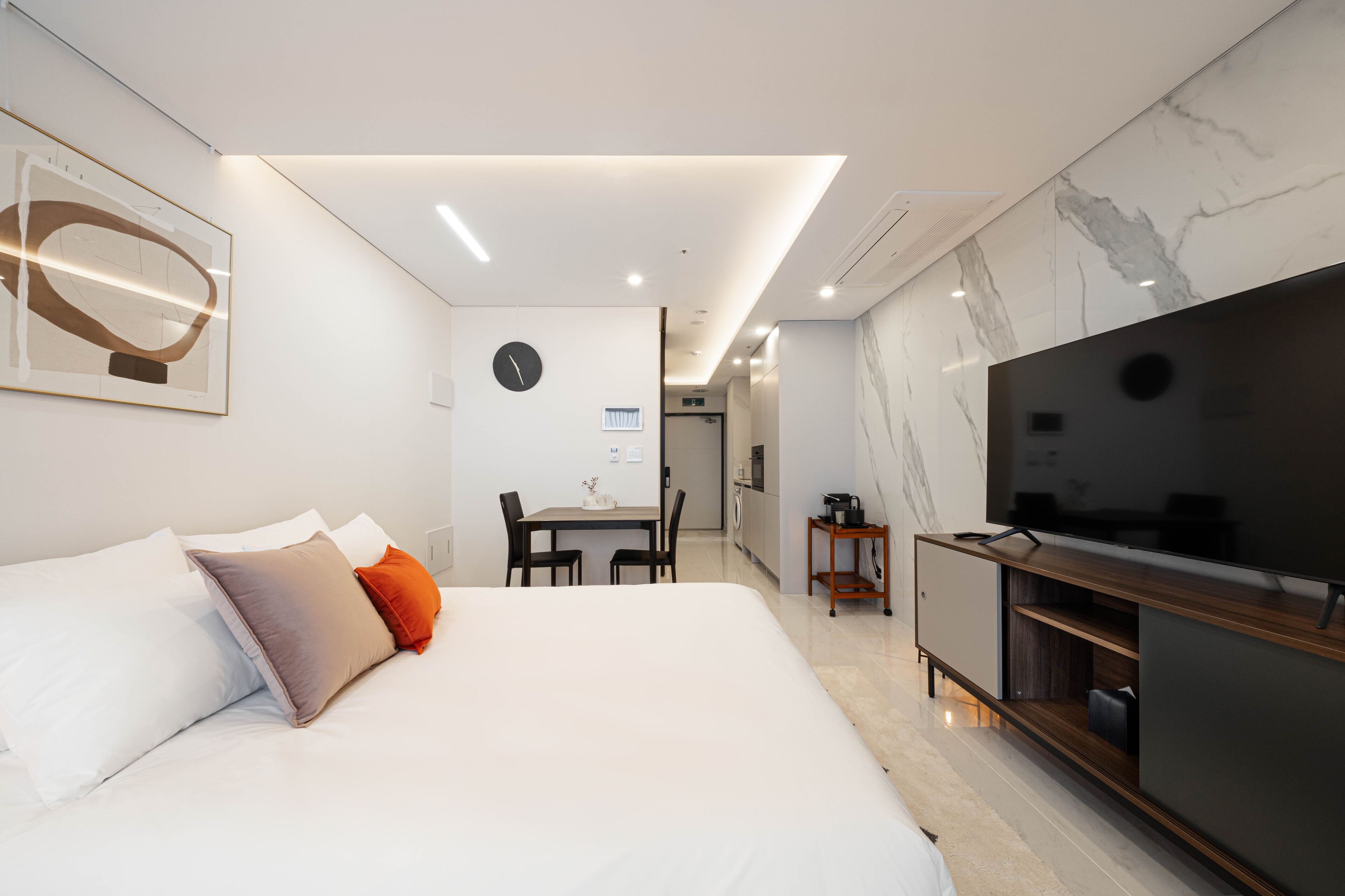 Et moderne hotelværelse med en stor seng, et spiseområde og et fjernsyn.