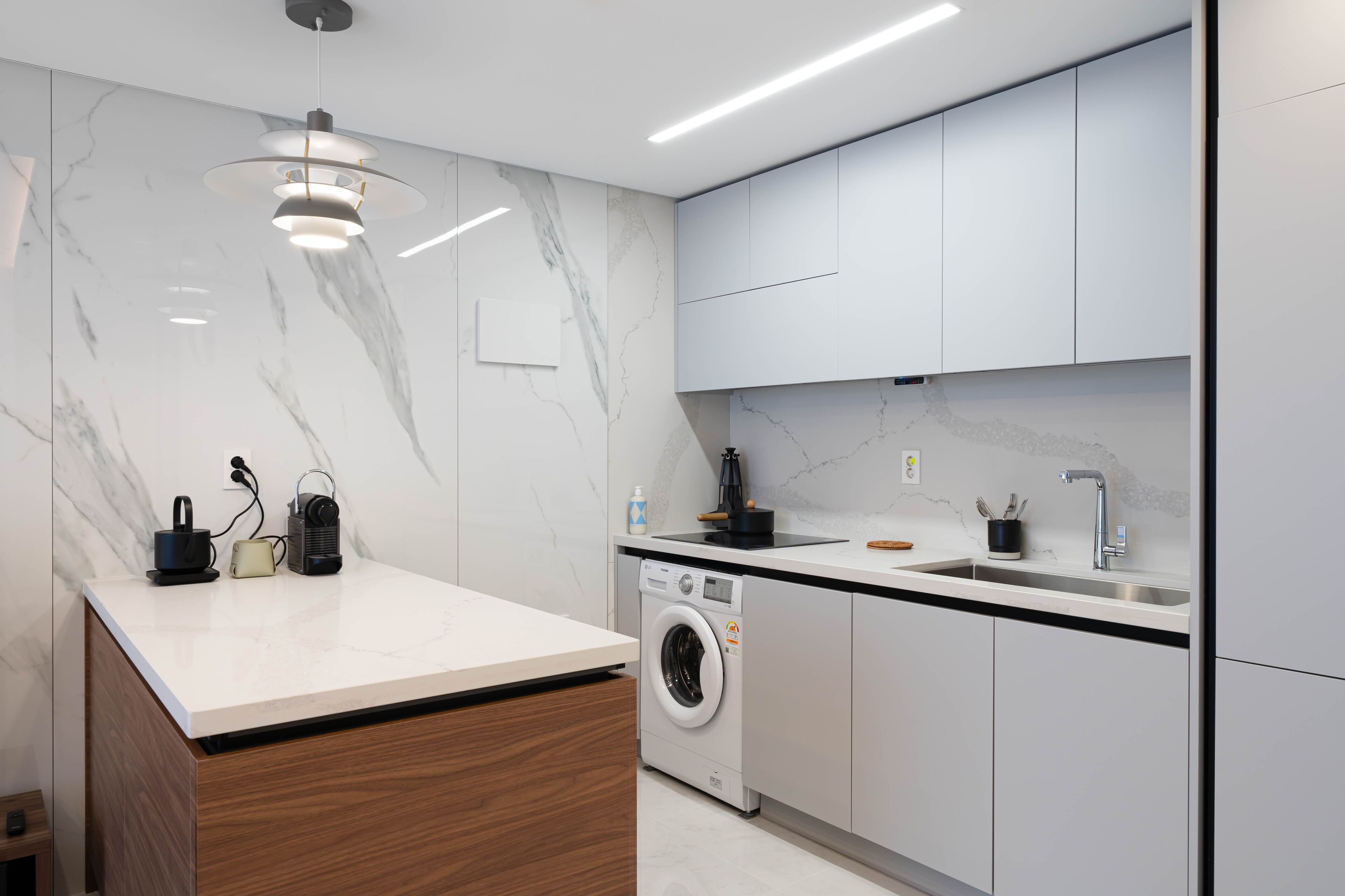 A modern kitchen with a built-in washing machine, a sink, and a countertop.