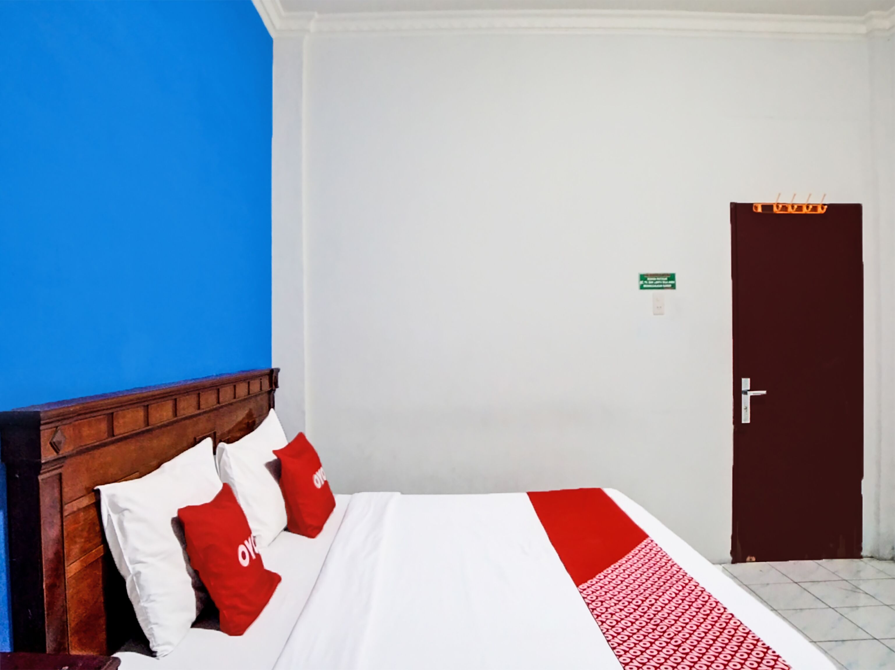 Una habitación de hotel con una cama, una puerta y una pared azul.