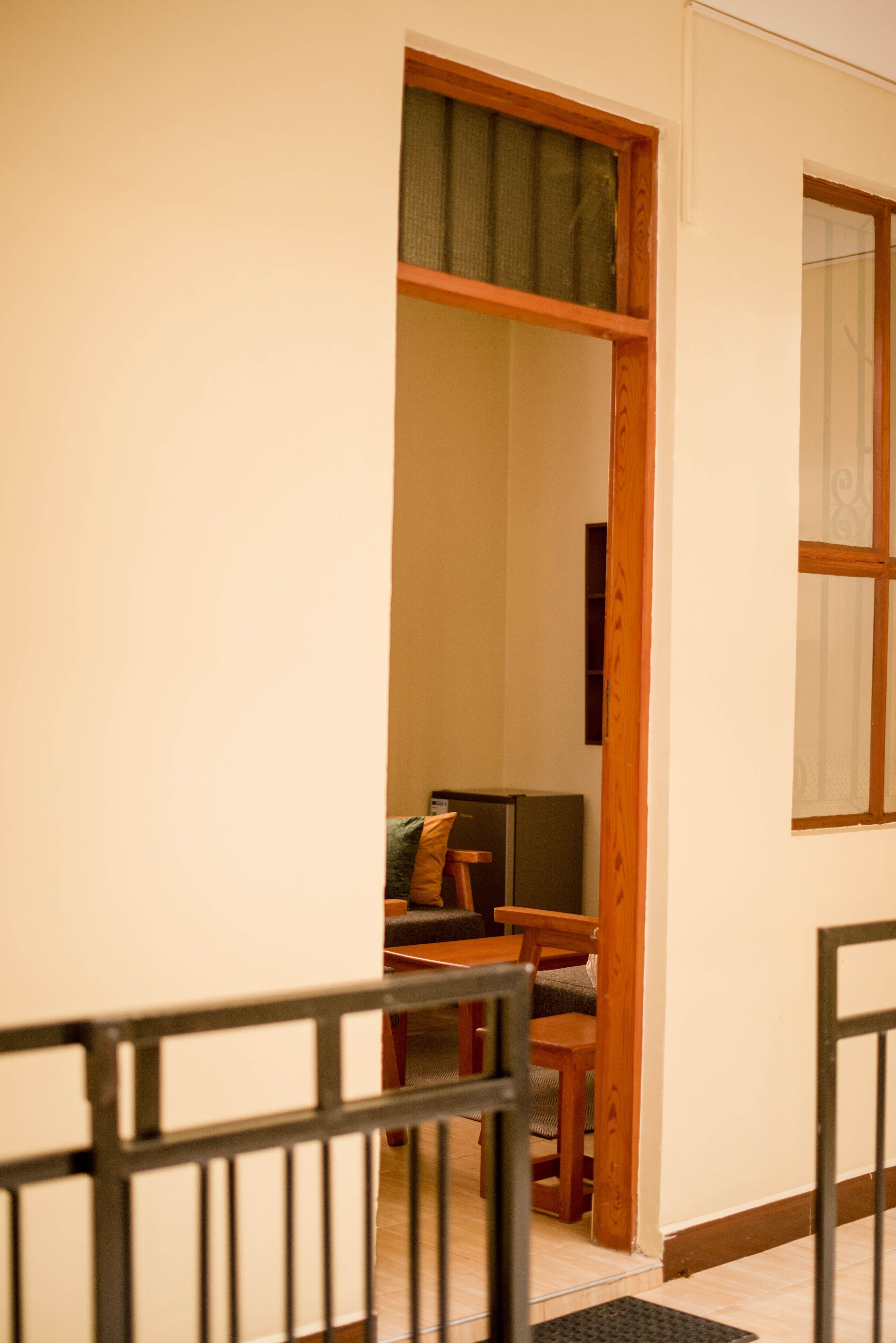 Un couloir étroit avec une porte en bois qui donne sur une pièce contenant un canapé et une petite table.