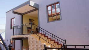 A modern two-story house with a staircase leading to a balcony. - HECASA HOMESTAY (Arusha)