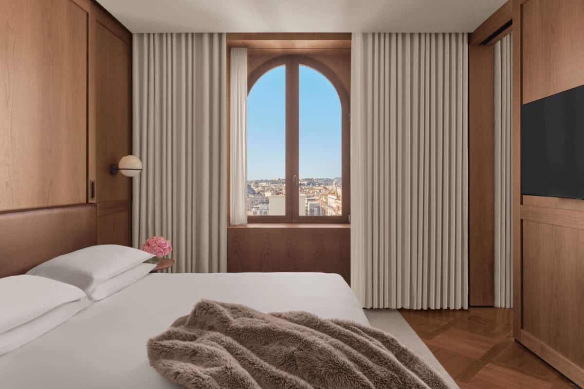 Una habitació d'hotel amb un llit gran, una vista per la finestra i panells de fusta.