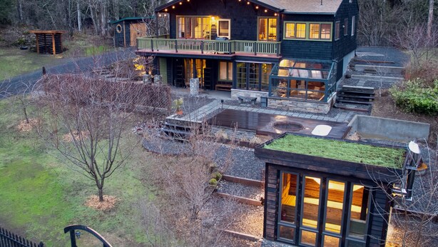 A two-story house with a balcony, a fire pit, and a covered outdoor seating area. - The Gorge Onsen Spa (Washougal)