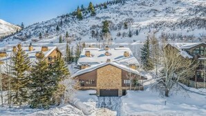 A snow-covered mountain landscape with a cluster of houses. - Luxe DV Condo at Snow Park (Park City)