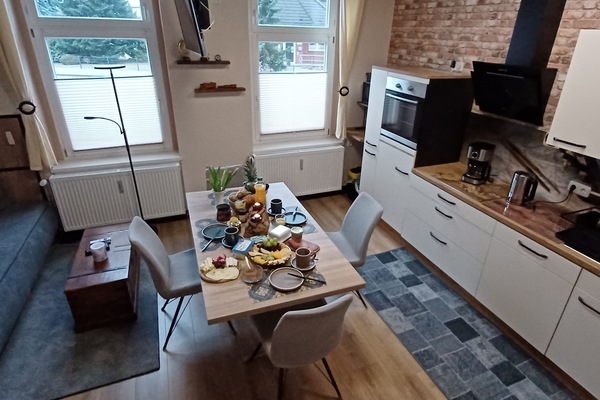 Wohnbereich mit offener Küche, Kamin und höhenverstellbarem TV