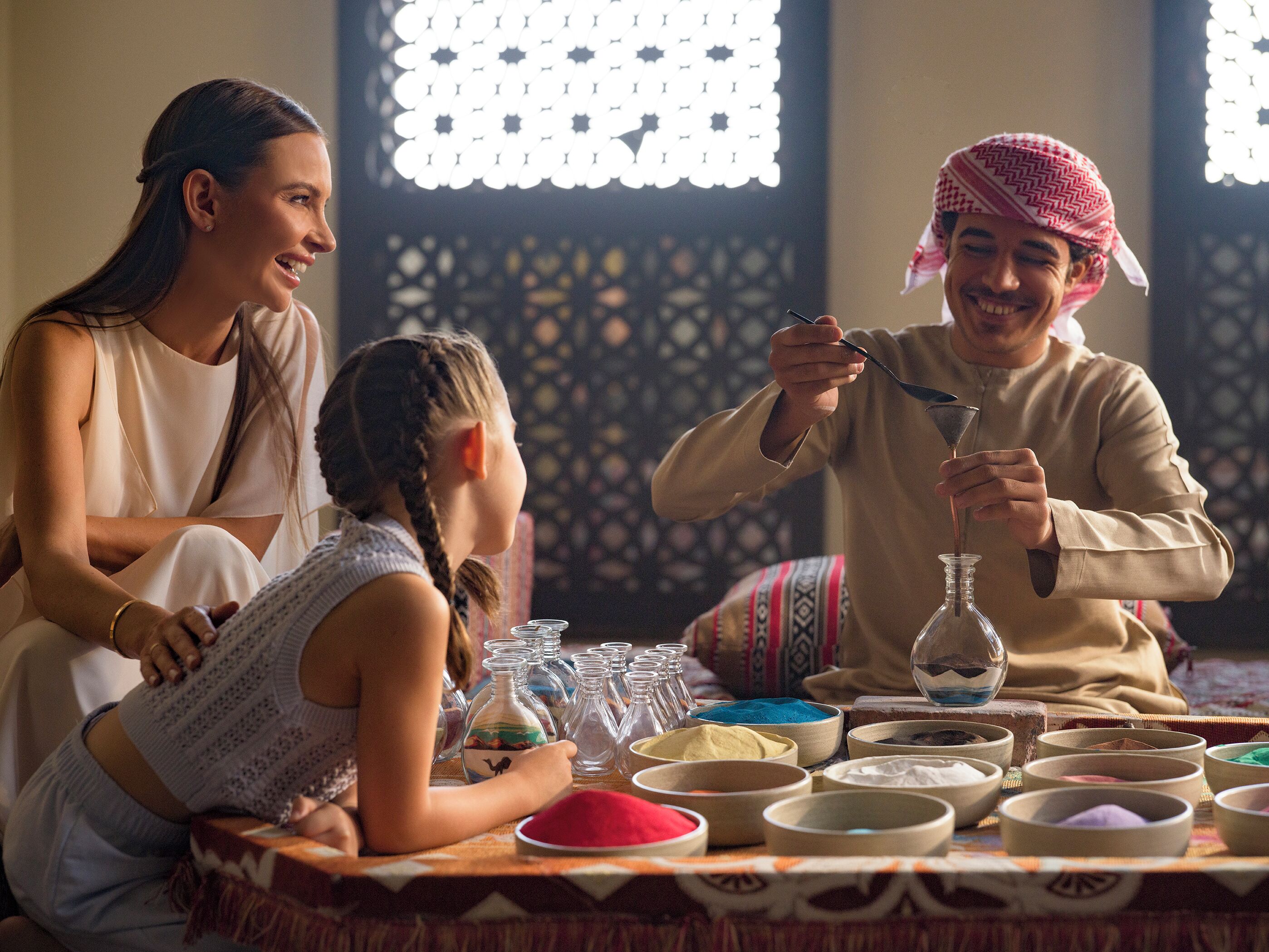 A family around a table with various containers and a traditional drink being prepared.