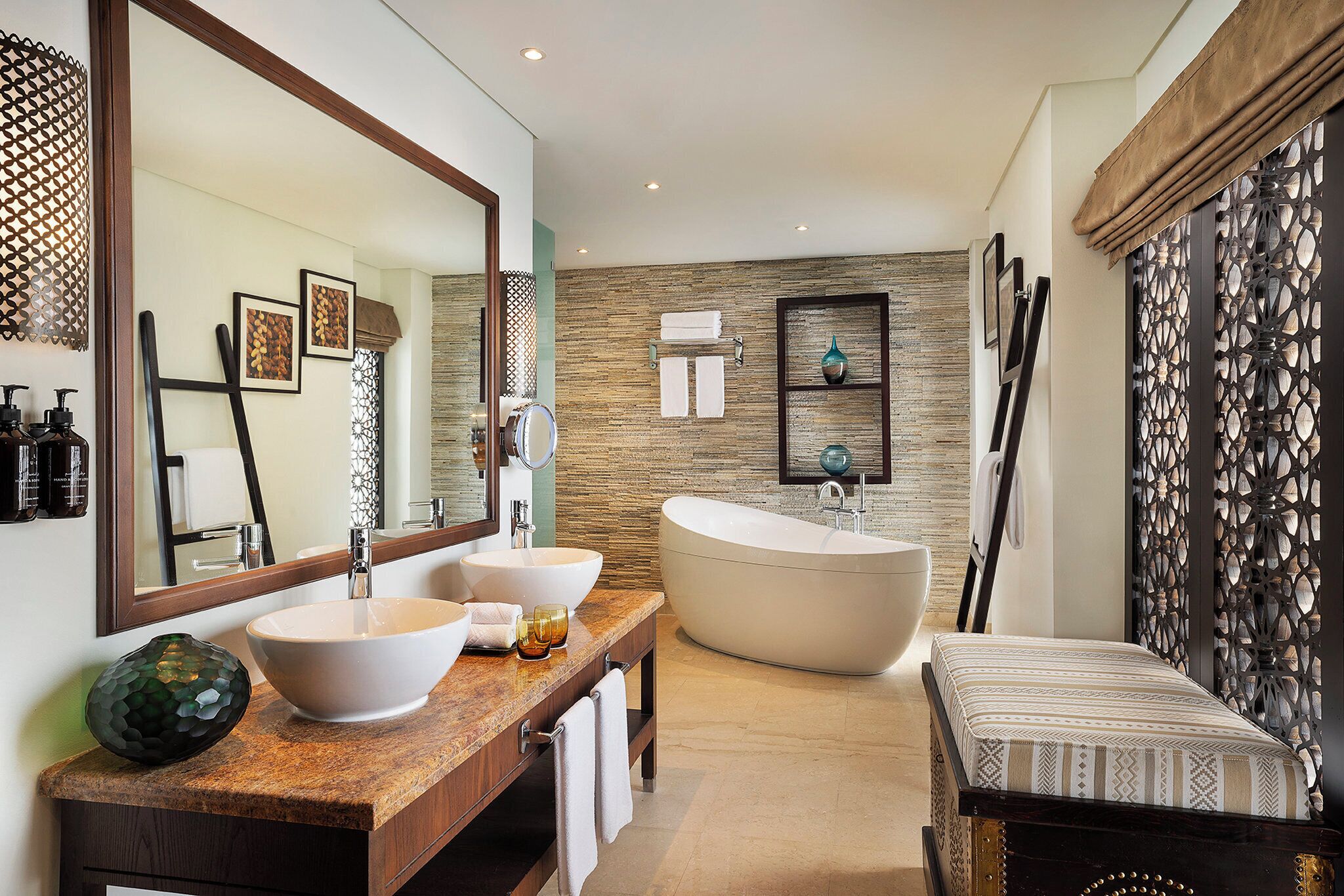 Une salle de bain moderne avec une baignoire sur pieds, un meuble-lavabo à deux vasques et un grand miroir.
