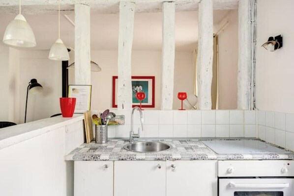 Kitchen features a sink, faucet, and oven, with ample counter space and storage.