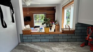 Una cocina con encimera de mármol, armarios de madera y vista a un comedor con mesa y sillas.