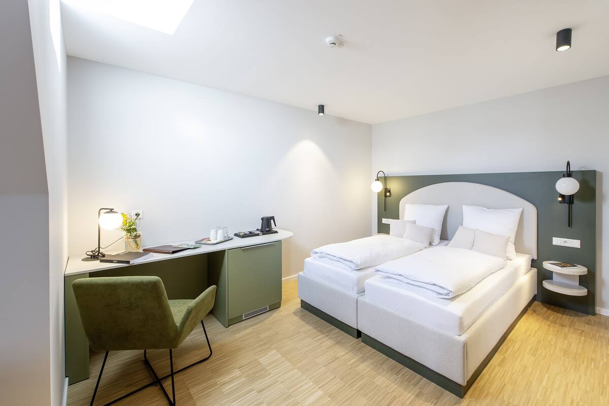 Una habitación de hotel moderna con cama, escritorio y silla.