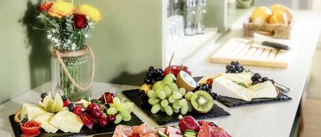 A variety of cheeses, fruits, and meats arranged on a counter.