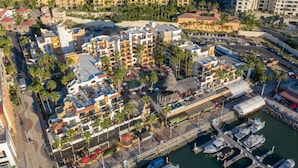 Un hôtel situé sur la côte, composé de plusieurs bâtiments, doté d’un port de plaisance et d’un espace piscine.