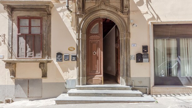 A building entrance with a wooden door, steps, and a mailbox. - Belvilla by OYO Maison (Fucecchio)