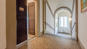 A hallway with a dark wooden door, a white door, and a staircase leading to an upper floor. - Belvilla by OYO Maison (Fucecchio)