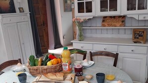 Ein Esstisch mit Frühstücksgebäck, umgeben von weißen Schränken und einer Holztür.