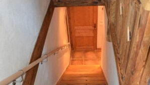 A wooden staircase with a handrail, leading to a door at the top.
