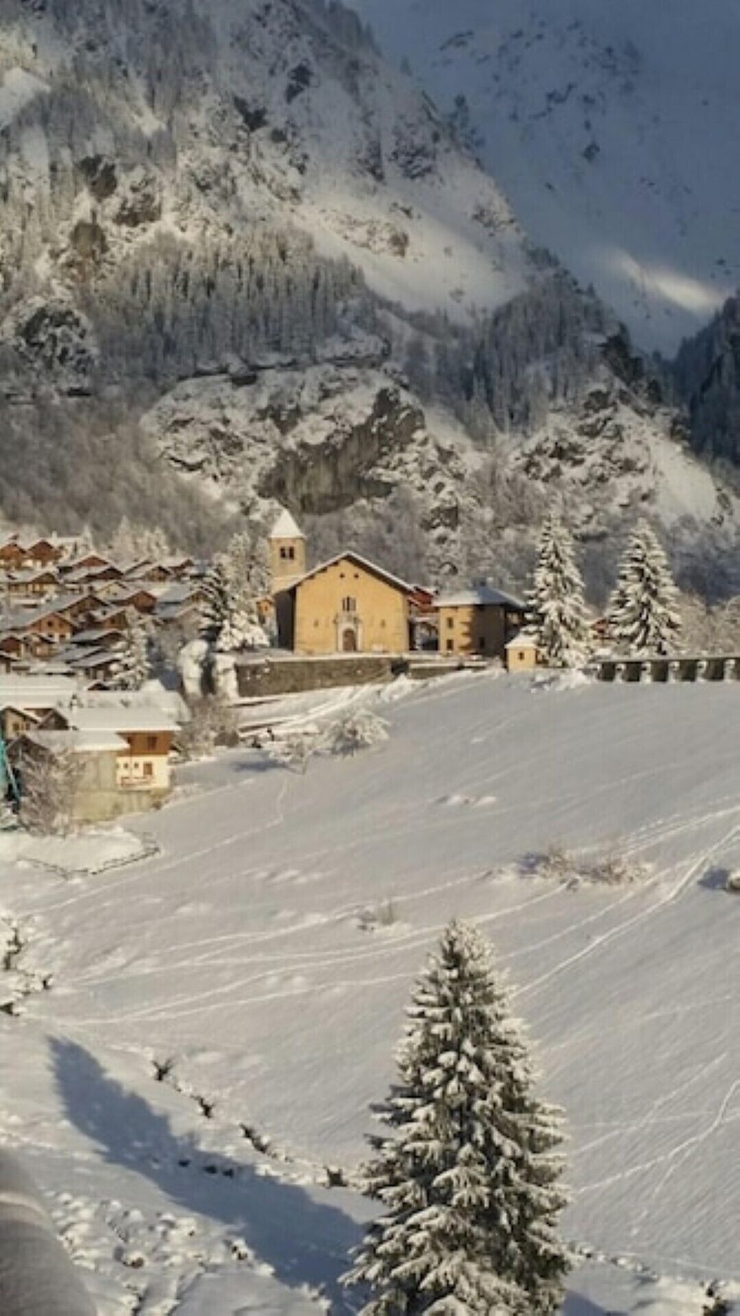 Un paysage enneigé avec une église et des bâtiments en arrière-plan.
