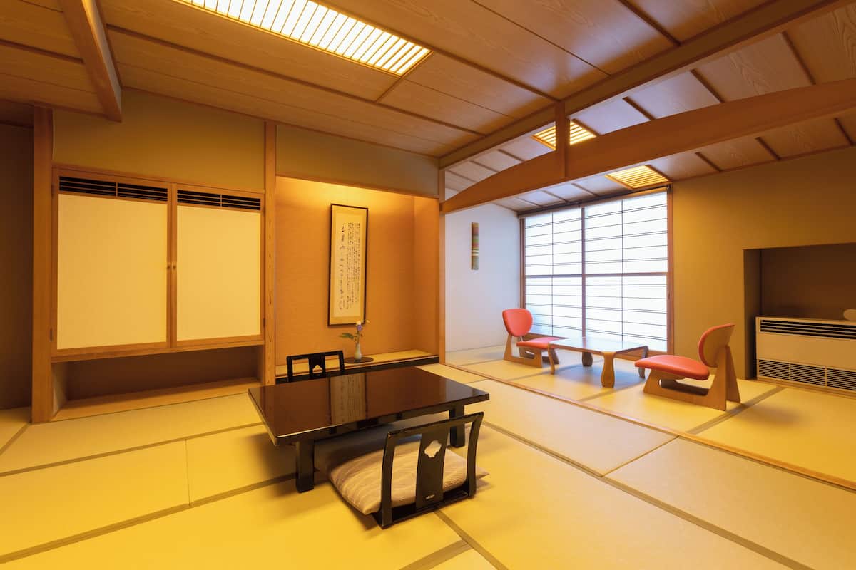 Ein traditioneller japanischer Raum mit Tatami-Böden, einem niedrigen Tisch und Holz-Schiebetüren.