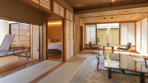 Een traditionele Japanse kamer met tatami vloeren, schuifdeuren, een bed, een eettafel en uitzicht op het omliggende landschap.