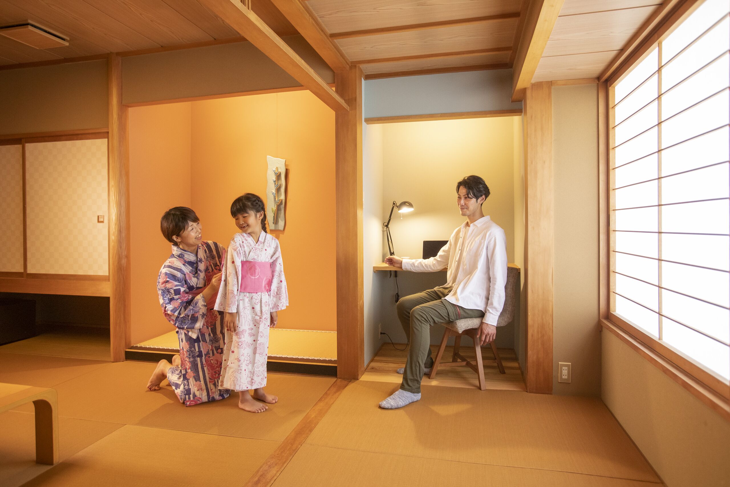 A traditional Japanese room with tatami flooring, a low table, and a sliding door.