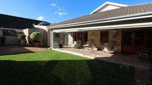 Une maison avec un patio, une pelouse et une pancarte indiquant «Bienvenue».