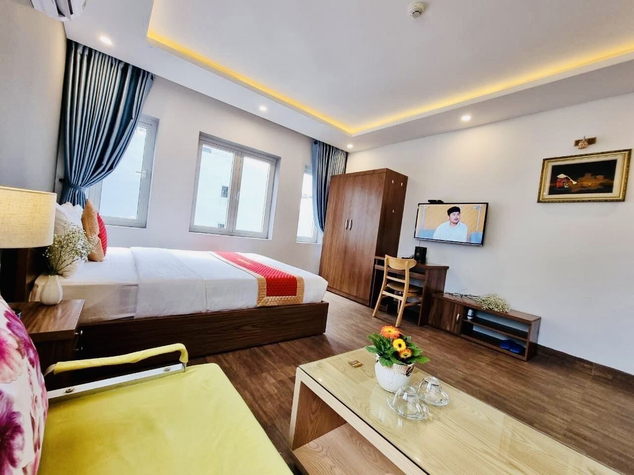Ein Hotelzimmer mit Bett, Schreibtisch, Stuhl, Fernseher und Fenster.