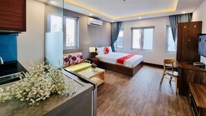 Une chambre d’hôtel moderne équipée d’un lit, d’un bureau et d’un coin salon.