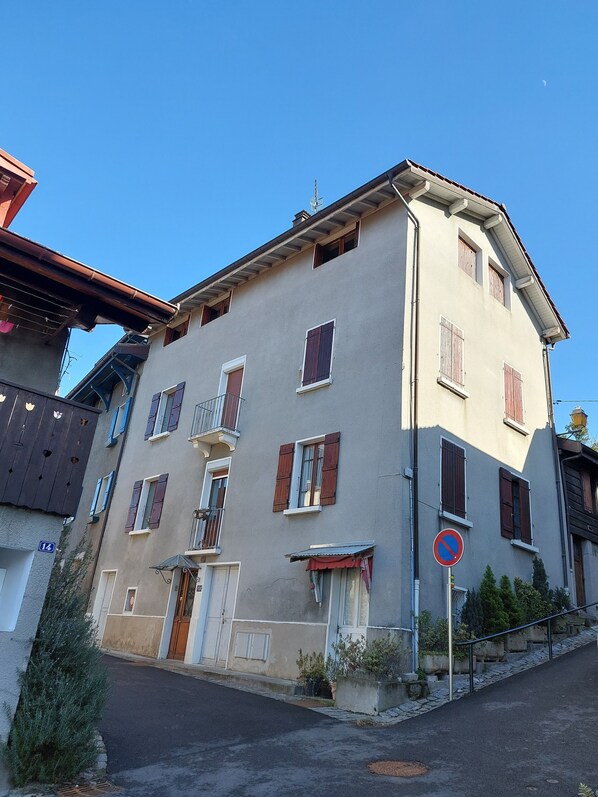 A two-story building with a balcony, a no parking sign, and a clear blue sky.