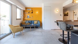 Ein modernes Wohnzimmer mit einer Couch, einem Couchtisch und einem Essbereich mit Tisch und Stühlen.